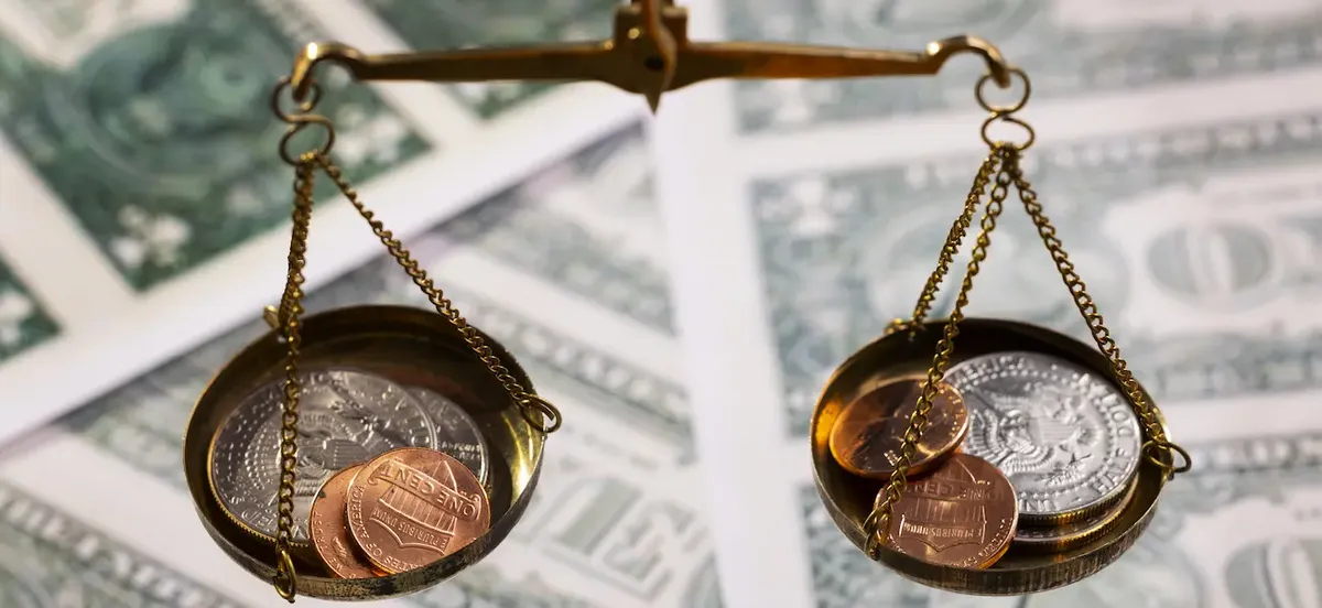 Bilancia con monete e banconote: rappresentazione del calcolo e dell'equilibrio fiscale nelle stock option.