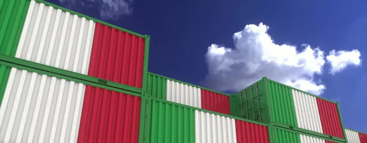 Container da spedizione decorati con i colori della bandiera italiana sotto un cielo azzurro, simboleggiando l'export per USA