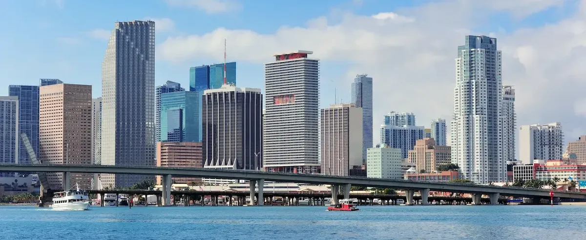 Skyline moderno di Miami con grattacieli e ponte sull'acqua, che simboleggia la crescita immobiliare della Florida