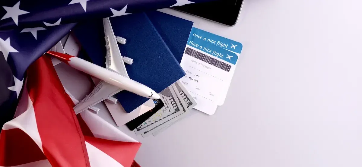 Passaporti, biglietti aerei, dollari USA e bandiera americana, simboli della riapertura dei viaggi negli Stati Uniti