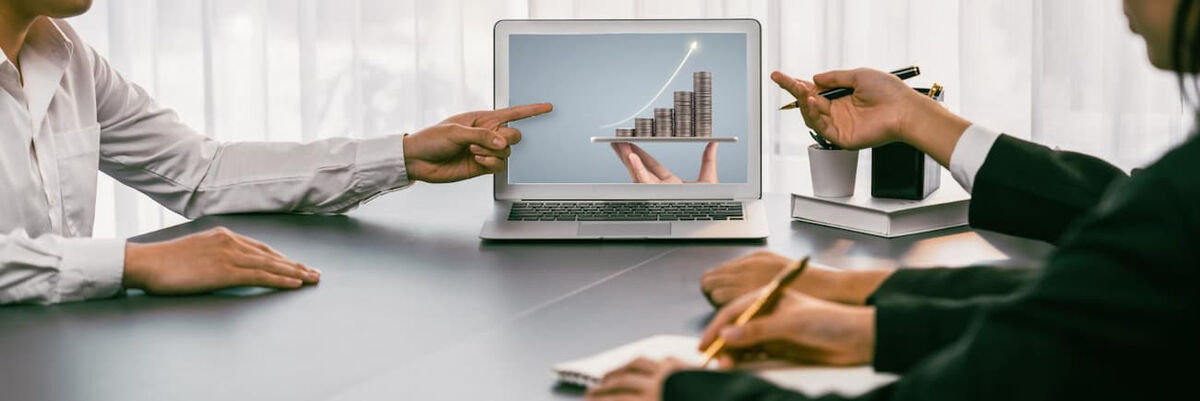 Professionisti in una riunione d'affari che analizzano un grafico di crescita economica su un computer portatile
