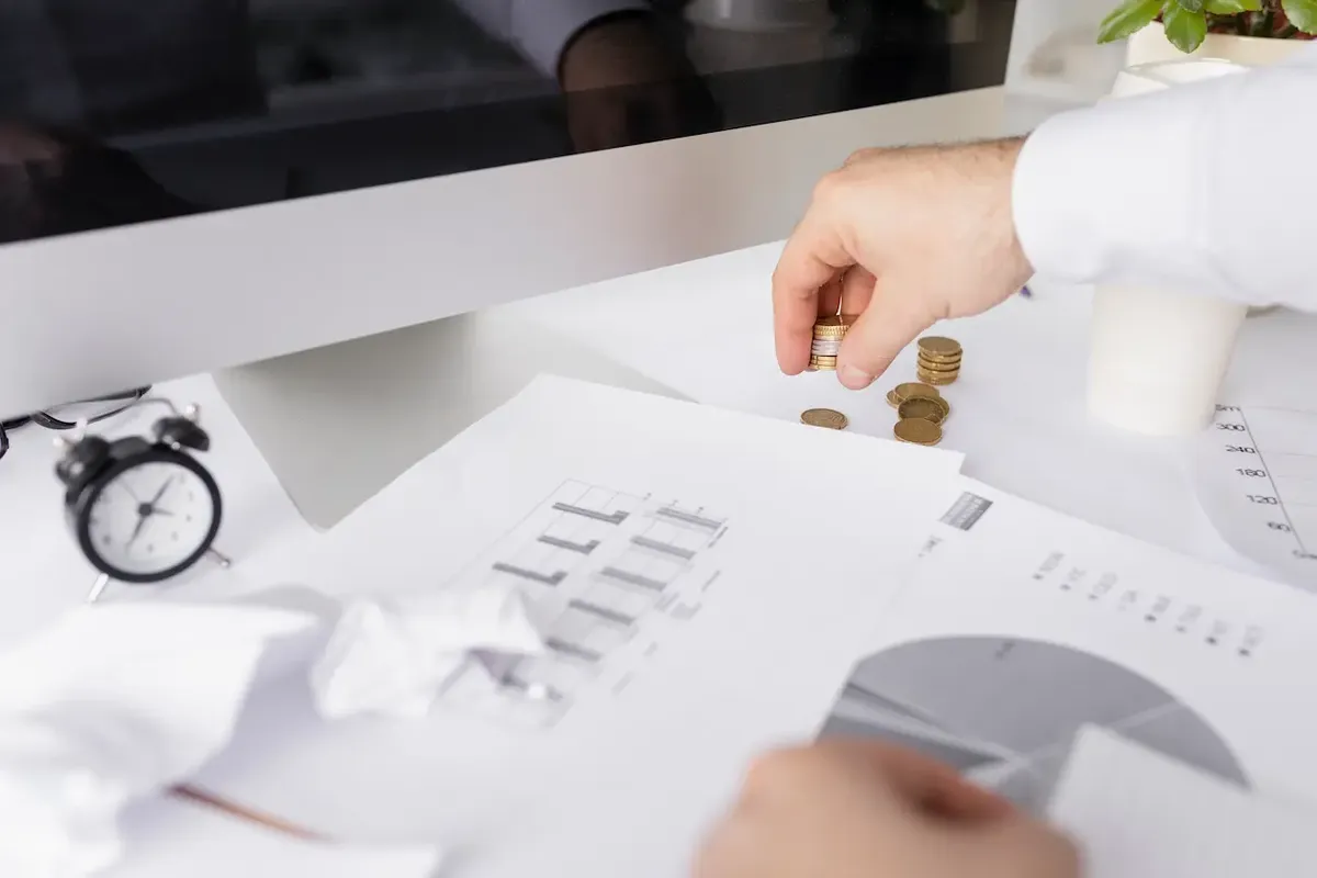 Documenti di bilancio e simboli di marchi/brevetti con elementi di calcolo finanziario, illustrano la valutazione degli asset intangibili aziendali.