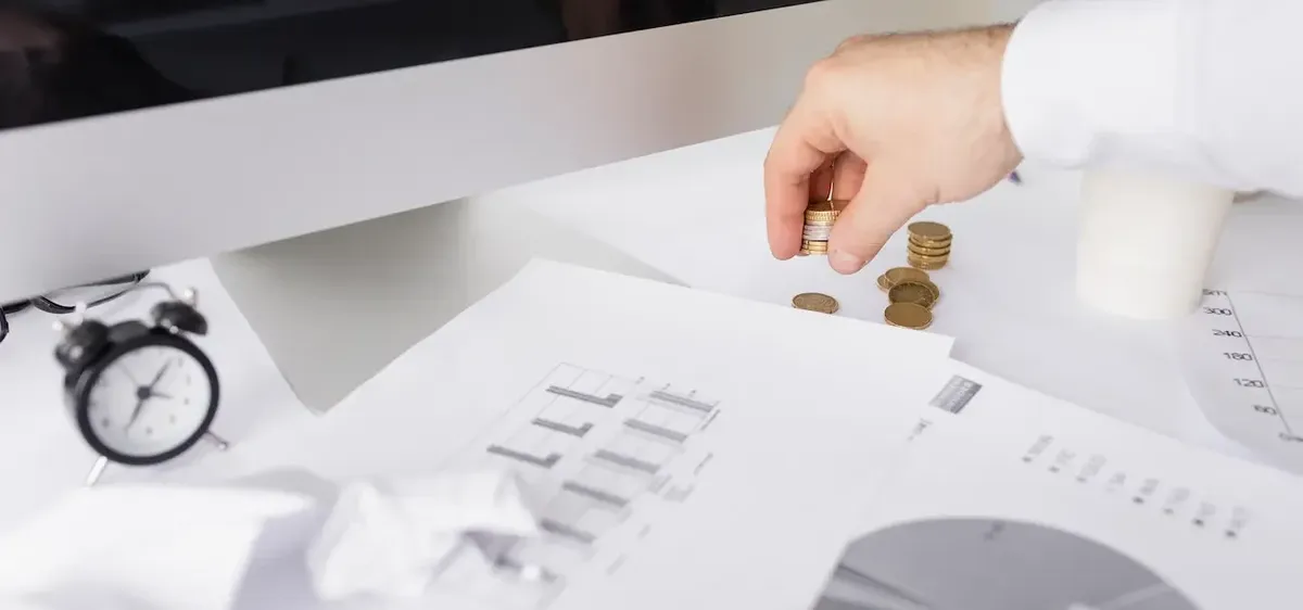 Documenti di bilancio e simboli di marchi/brevetti con elementi di calcolo finanziario, illustrano la valutazione degli asset intangibili aziendali.