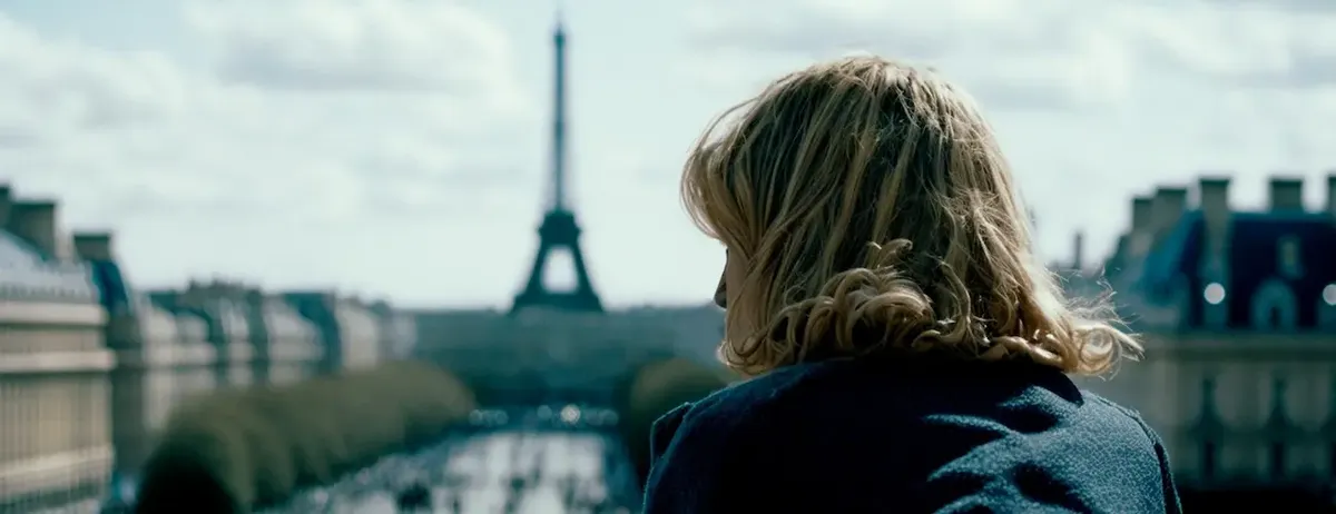 Donna bionda di spalle che osserva il panorama di Parigi con la Torre Eiffel, evocando un'atmosfera di alta moda e contemplazione