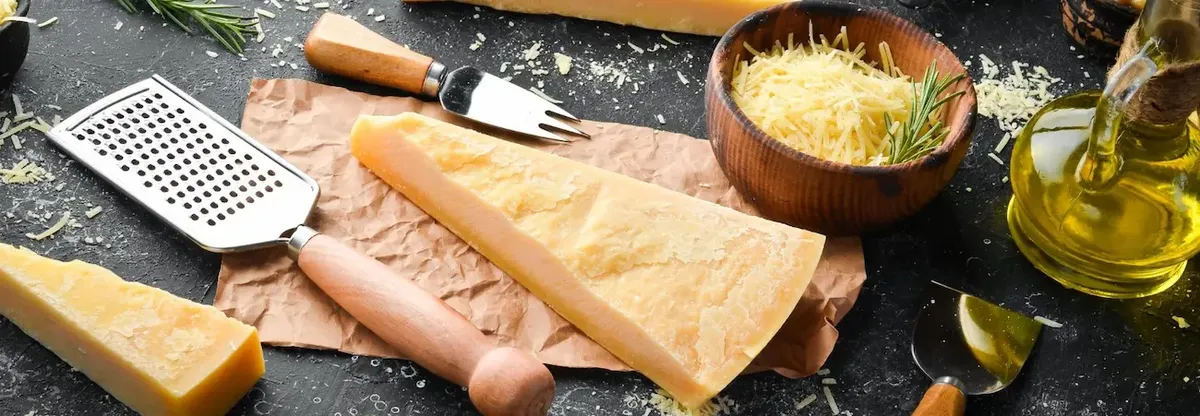 Tavolo con formaggio parmigiano e olio, che rappresenta i prodotti di alta qualità del Gruppo Granarolo