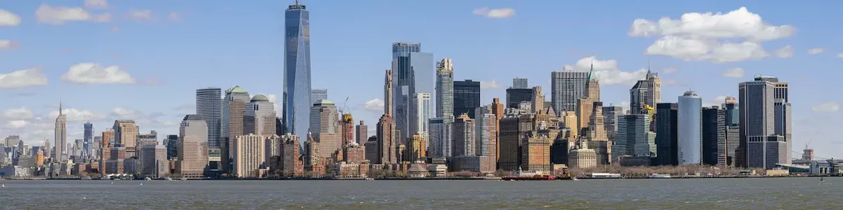 Panorama urbano di New York City visto dall'acqua, con i grattacieli iconici di Manhattan, a simboleggiare l'espansione di un brand di moda a New York