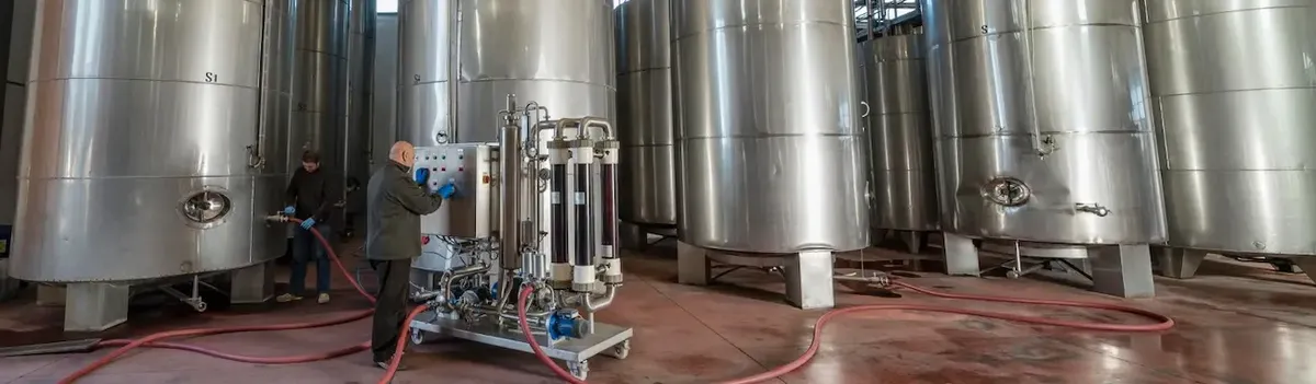 Interno di una cantina vinicola moderna con serbatoi in acciaio, che rappresenta la nuova tecnologia per il vino senza solfiti